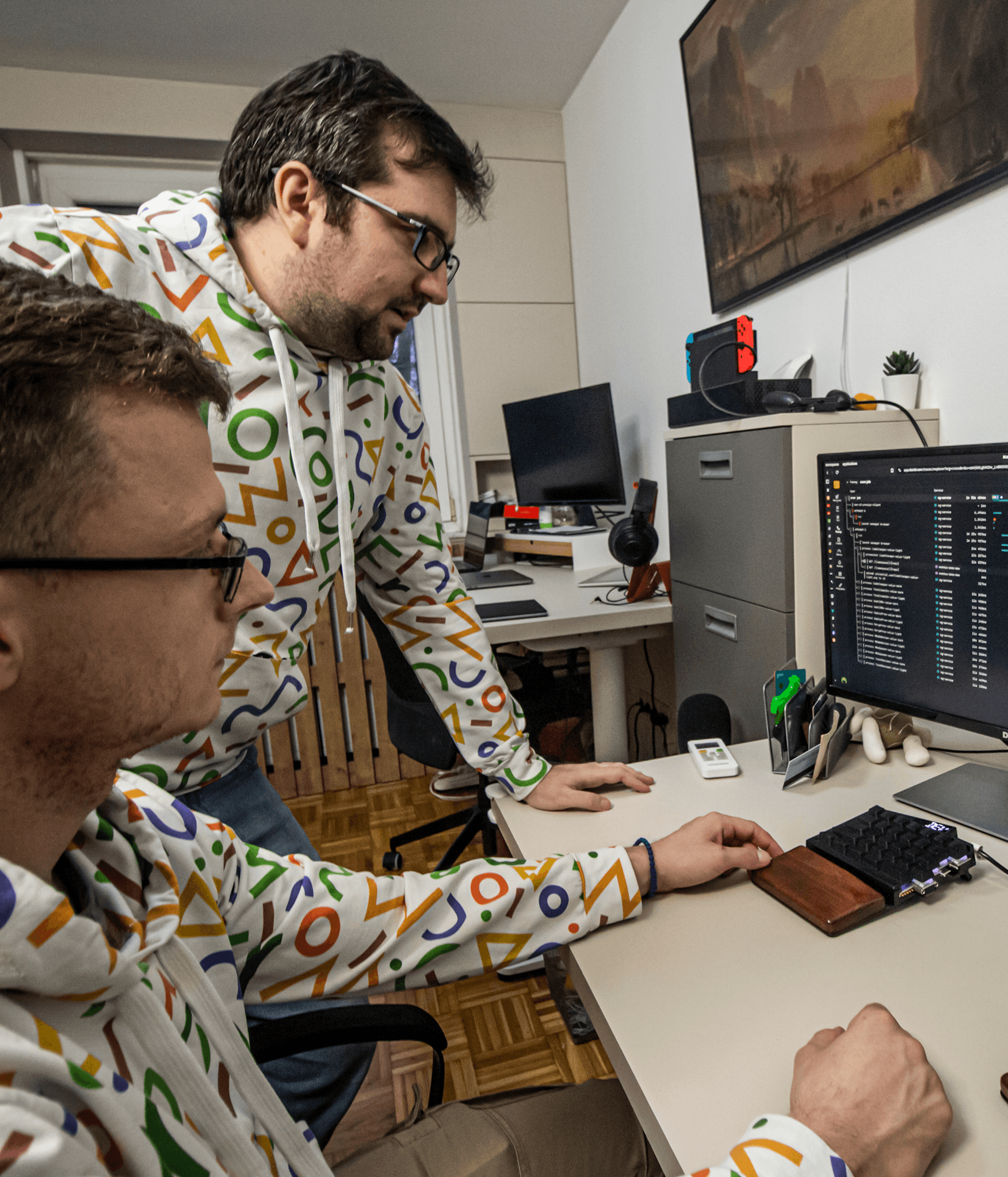 Two male developers in CroCoder hoodies collaborating
